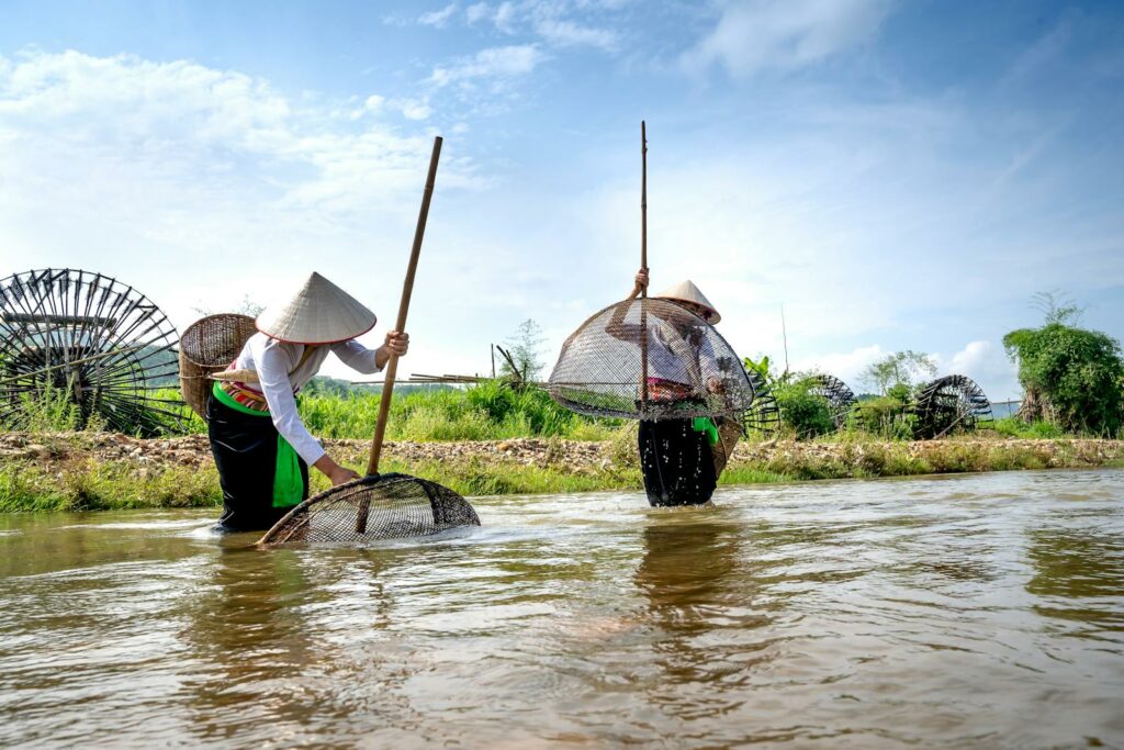 Female anglers catching fish in pond